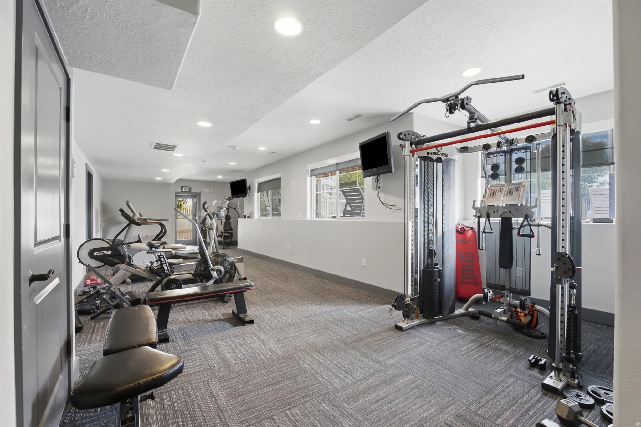 Dedicated fitness room featuring recessed lighting and patterned carpet flooring