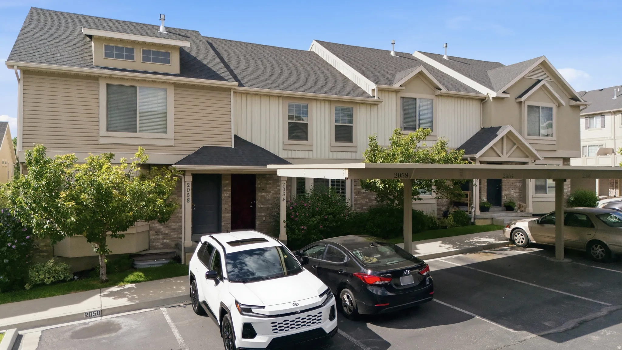 Exterior facade featuring siding and stone accents, covered entryways, and dormer windows