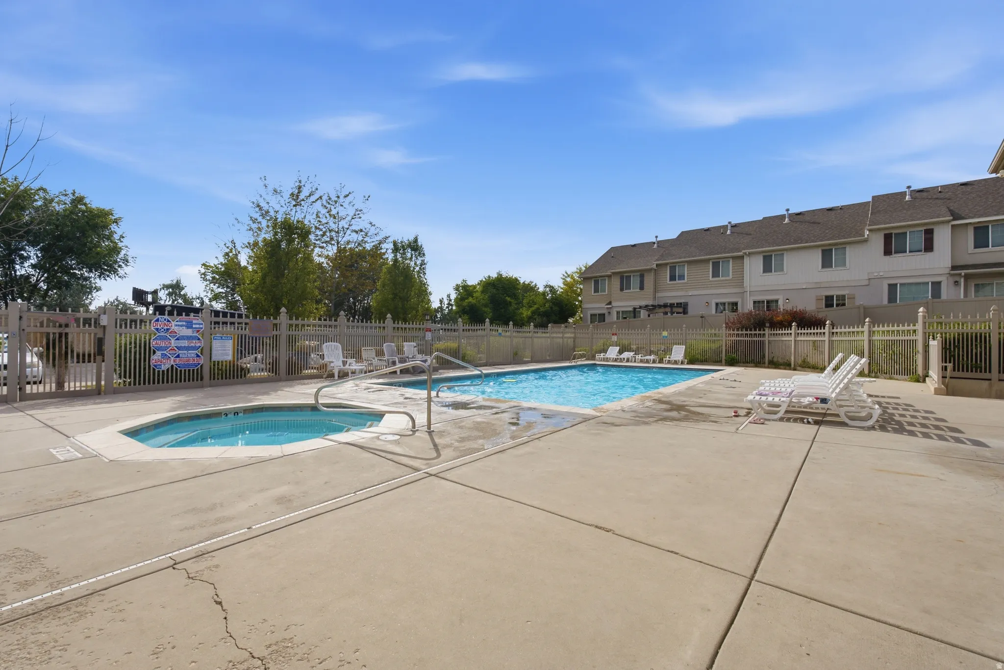 Outdoor amenity space featuring a rectangular swimming pool and an adjacent spa