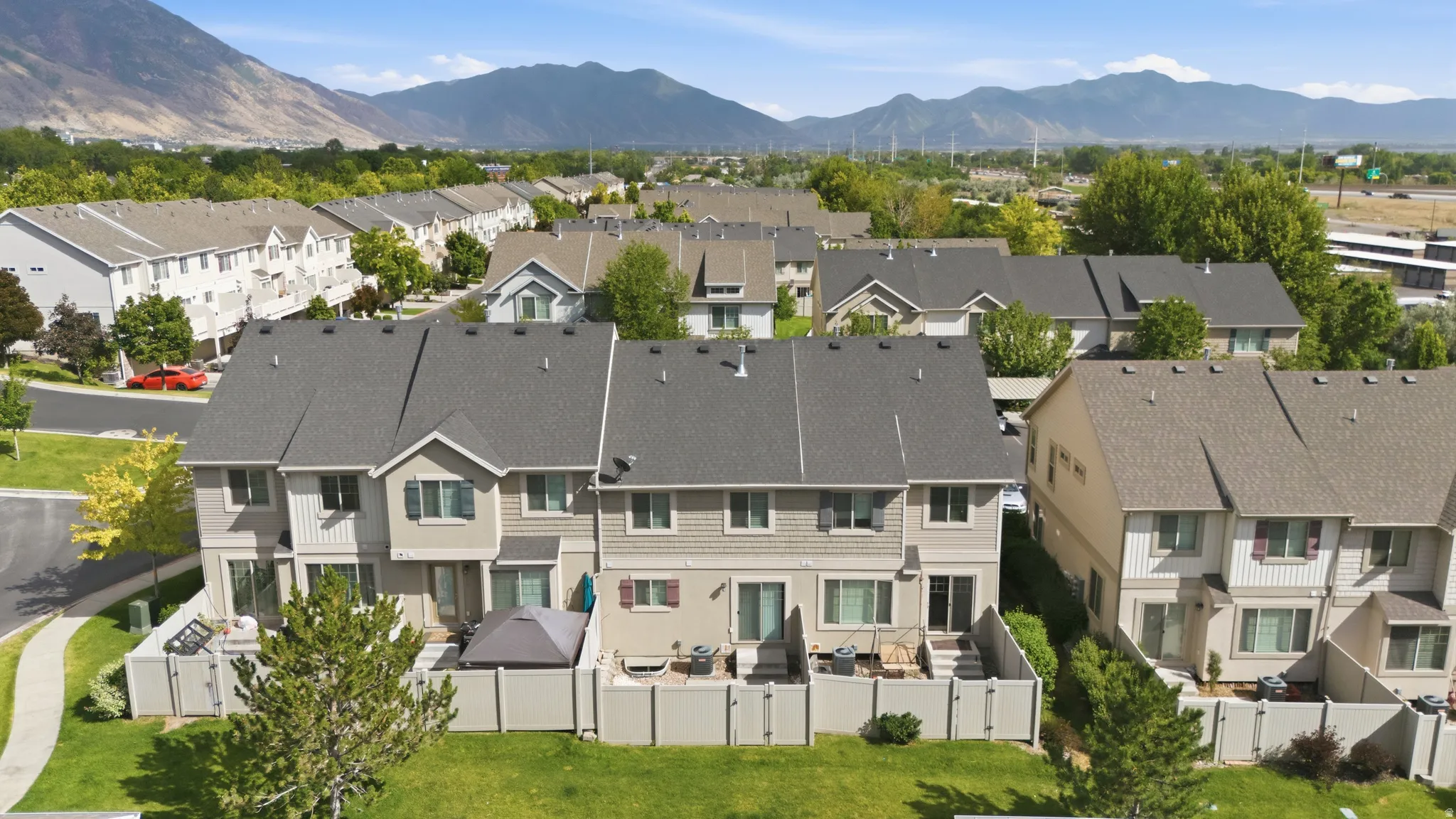 Townhome community featuring multi-level residences with private patios and mountain backdrops