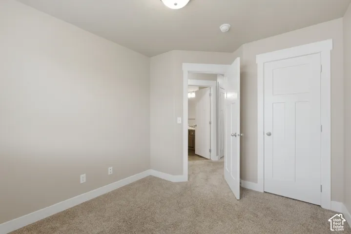 Carpeted room with neutral wall paint and white trim