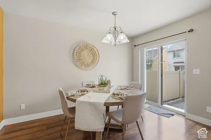 Dining area featuring wood-finish flooring, a contemporary chandelier, and a sliding glass door opening to a private outdoor space