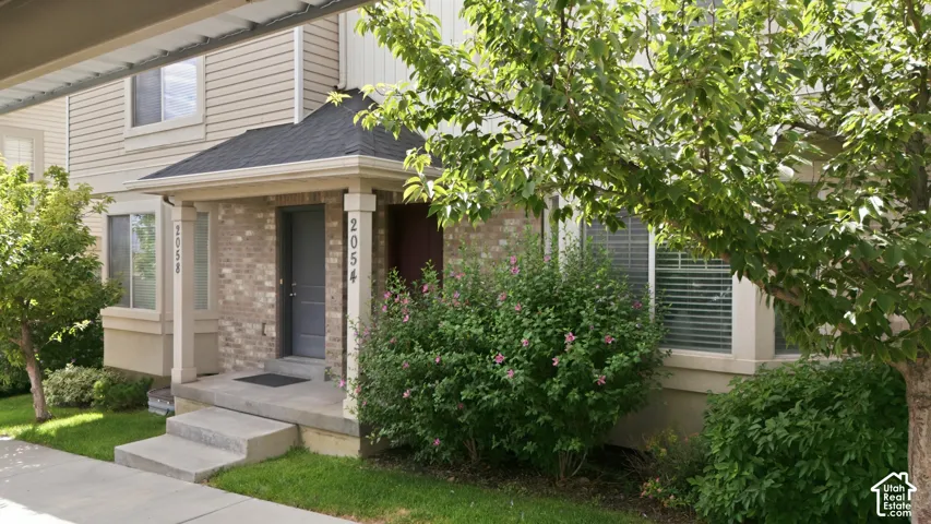 Brick and siding exterior featuring a covered entryway with decorative pillars