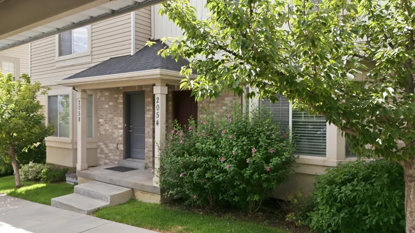 Brick and siding exterior featuring a covered entryway with decorative pillars