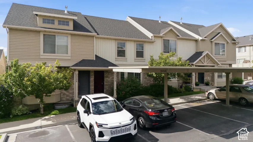 Exterior facade featuring siding and stone accents, covered entryways, and dormer windows