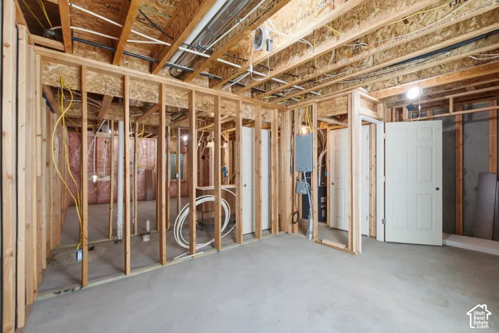 Unfinished basement space featuring visible wood framing, concrete flooring, and exposed ceiling joists