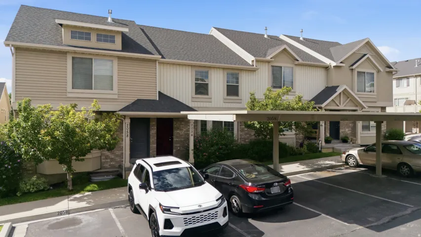 Exterior facade featuring siding and stone accents, covered entryways, and dormer windows