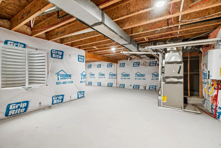Unfinished lower level with exposed wood joist ceiling