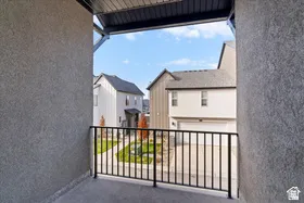 Private balcony featuring a black metal railing and textured exterior wall