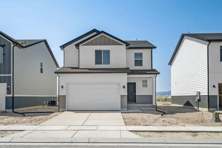 **DISCLAIMER** Elevation may vary. Two-story residence featuring a clean facade of light-colored siding, a pitched roof with dark shingles, and a two-car garage with a paneled door