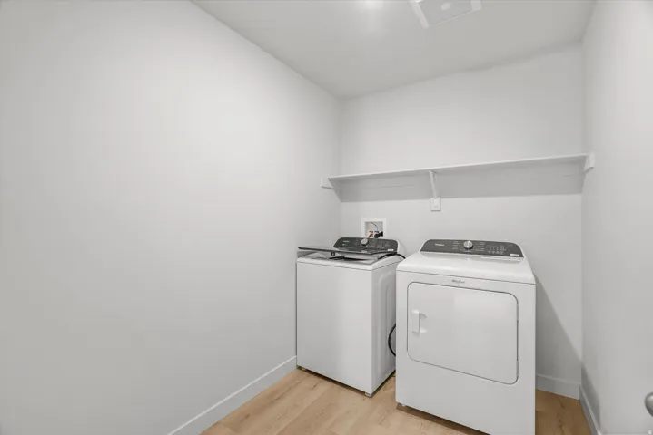 Utility area featuring wood-finish flooring and a built-in storage shelf