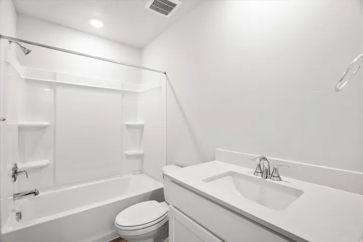 White solid surface countertop with integrated rectangular sink and chrome faucet