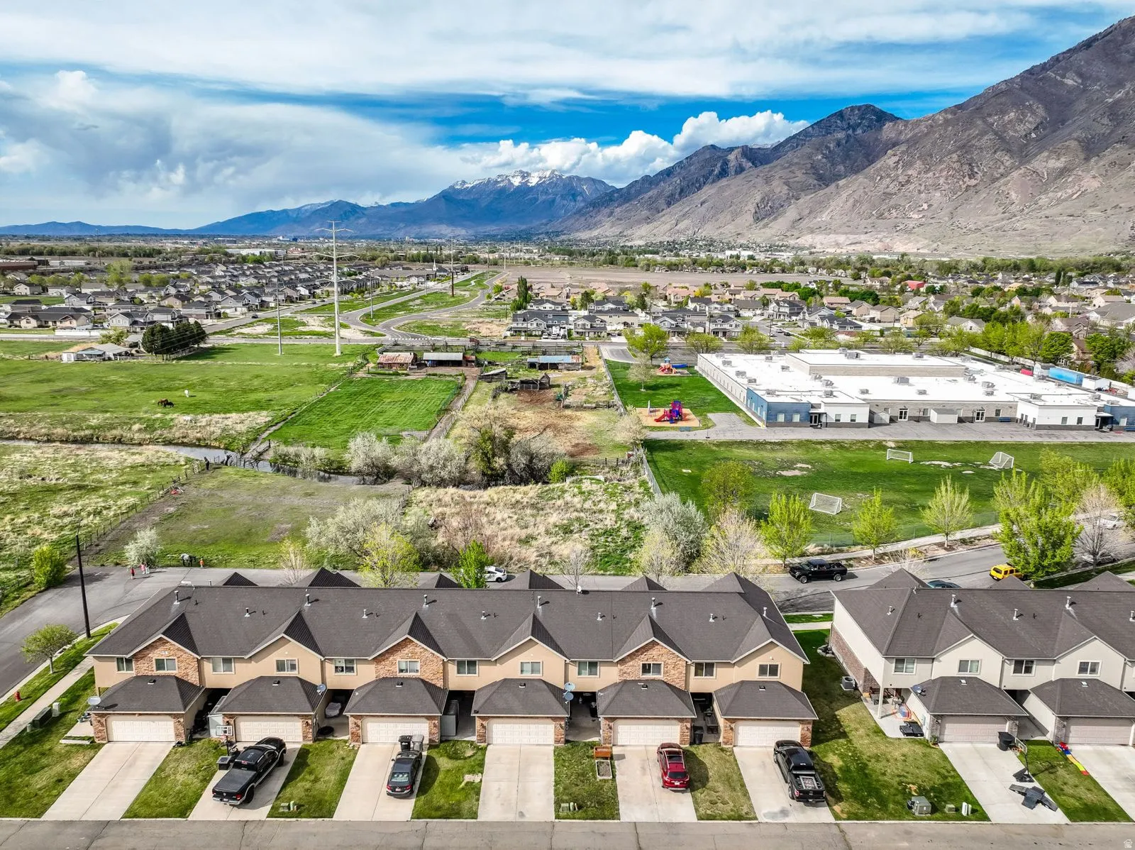 Contemporary townhome row featuring brick and siding exteriors, individual attached garages, and private driveways