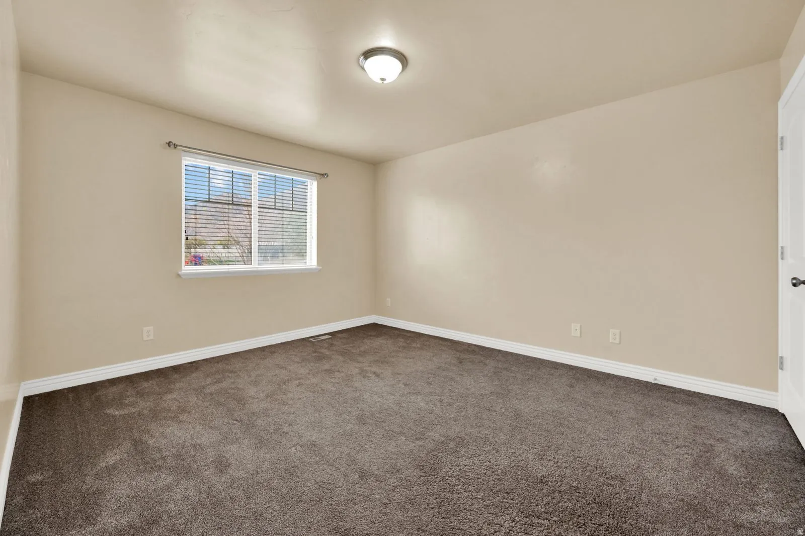 Neutral-toned walls complement the dark carpeting