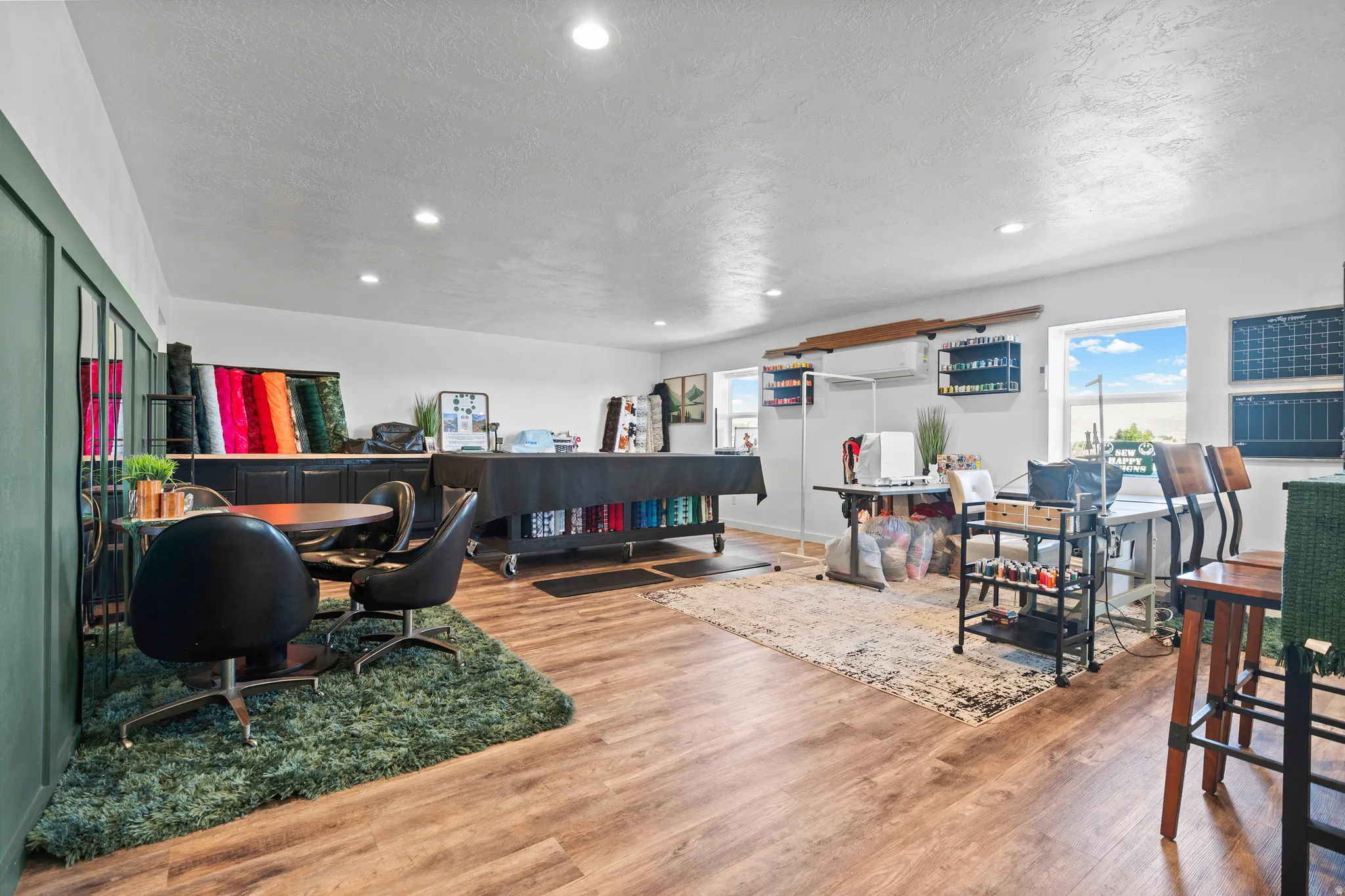 Spacious room featuring wood-finish flooring, recessed lighting, and multiple windows providing natural illumination