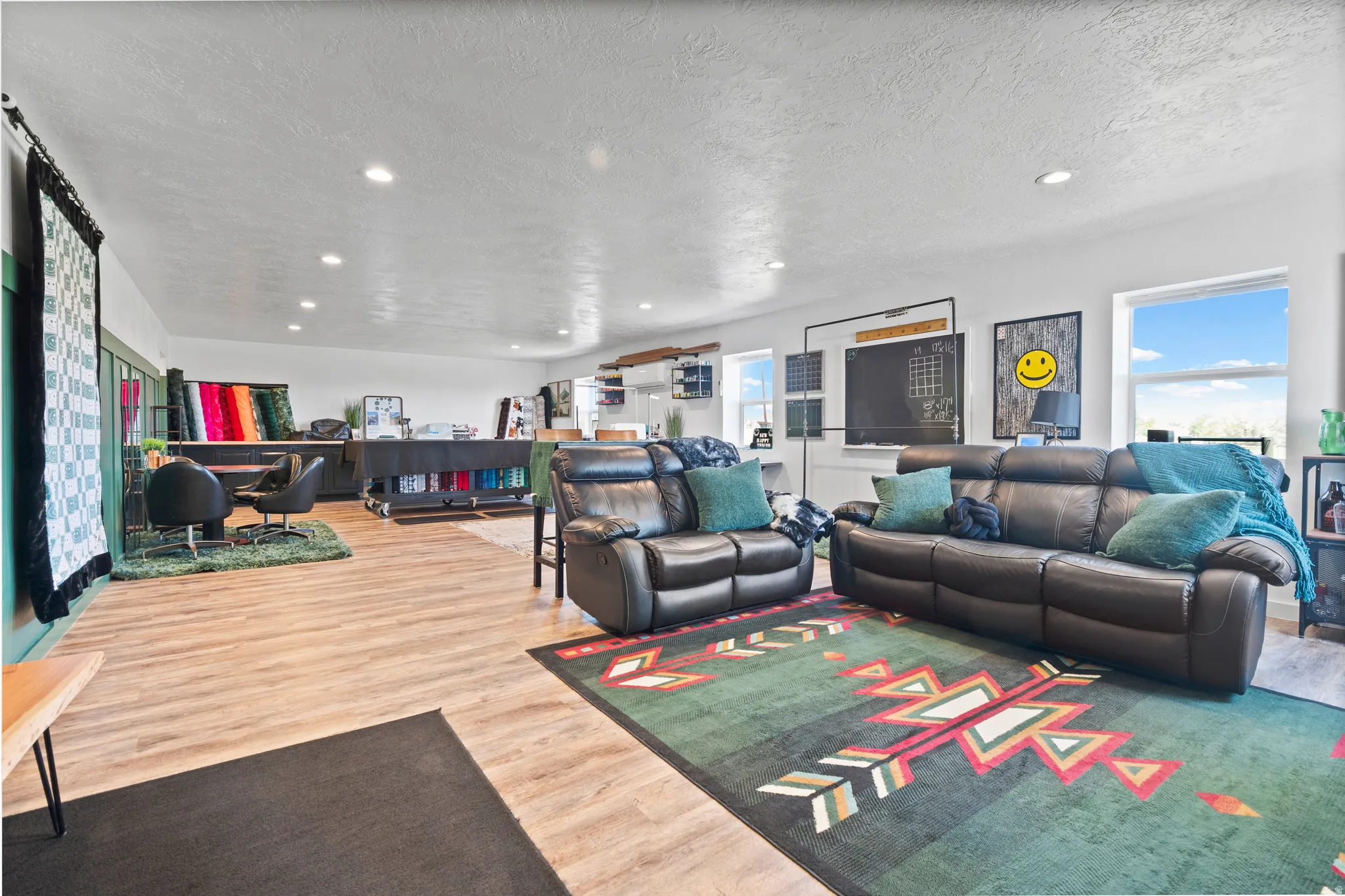 Open-concept room featuring wood-finish flooring, recessed lighting, and multiple windows providing natural light