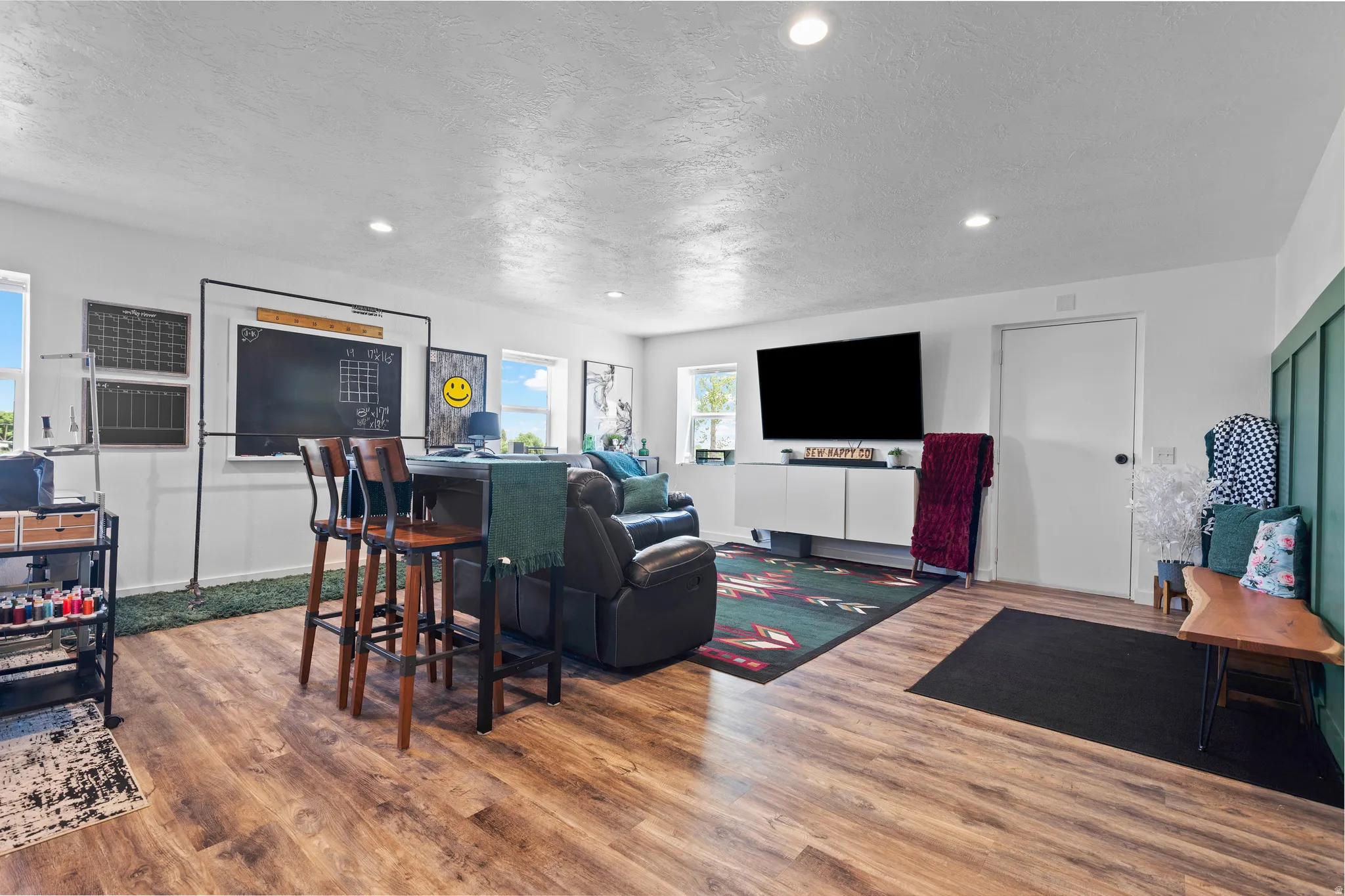 Spacious room featuring wood-finish flooring, recessed lighting, and multiple windows