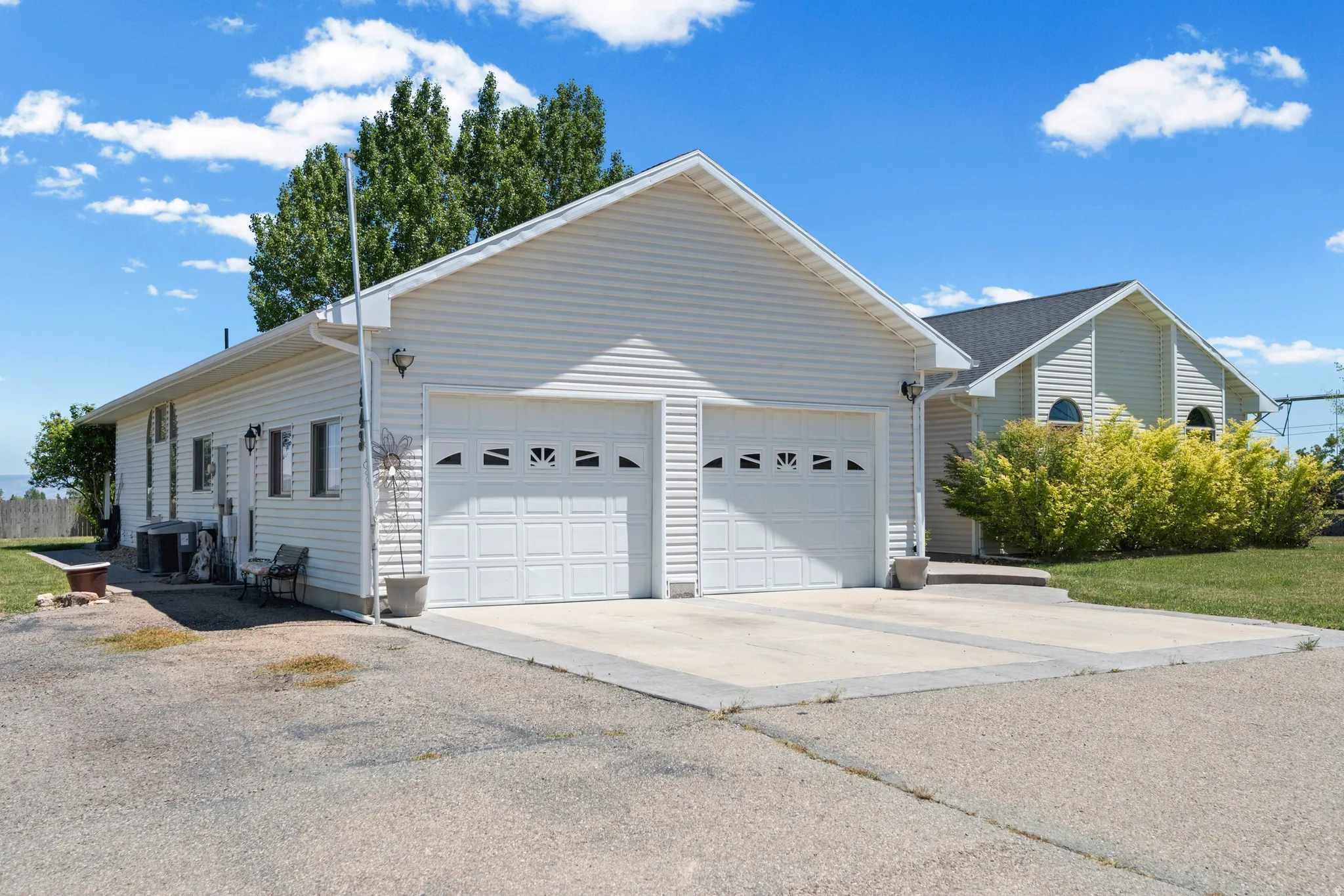 Attached two-car garage featuring panel doors with decorative windows and concrete driveway