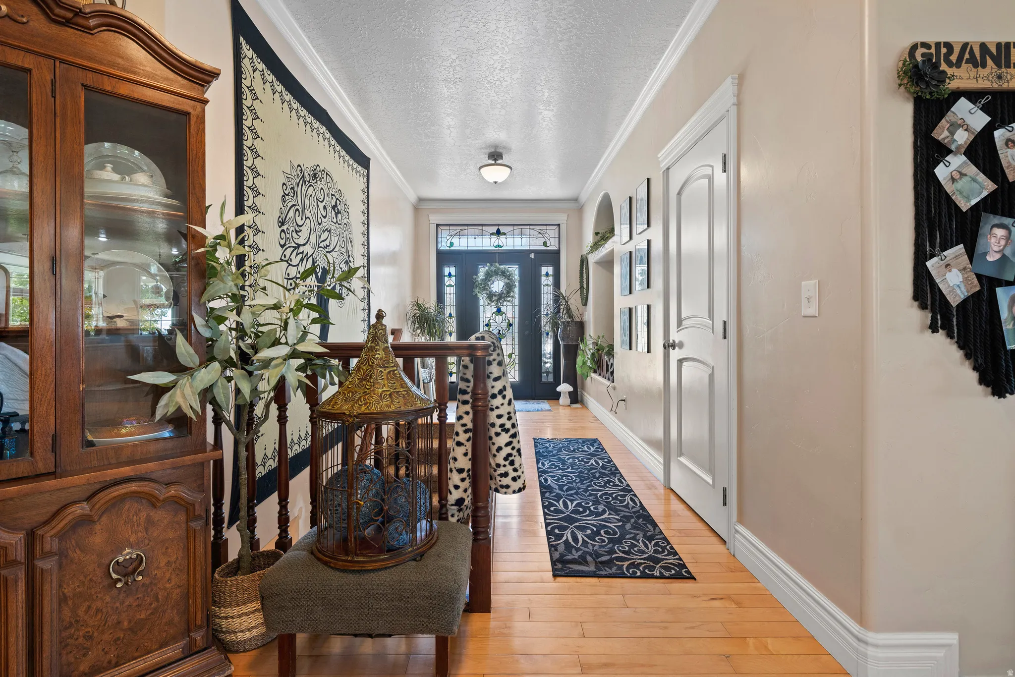 Foyer featuring wood-finish flooring, light-toned walls, white trim, and a decorative front door with transom and sidelight windows