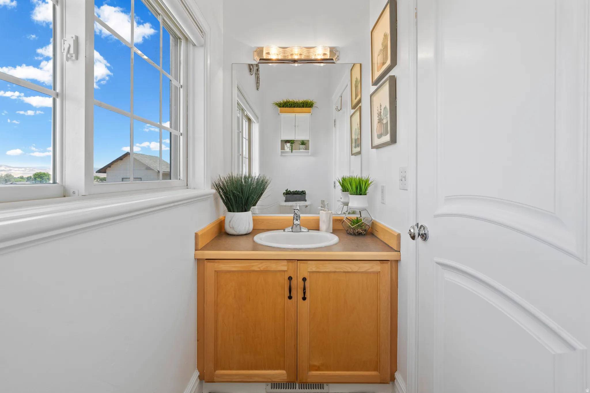 Vanity area featuring a wood-finish cabinet, integrated sink, and an overhead light fixture