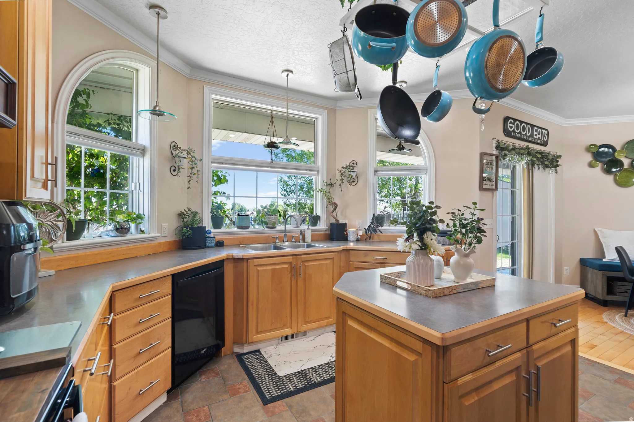 Kitchen featuring light wood cabinetry, a central island with countertop, and an integrated double basin sink
