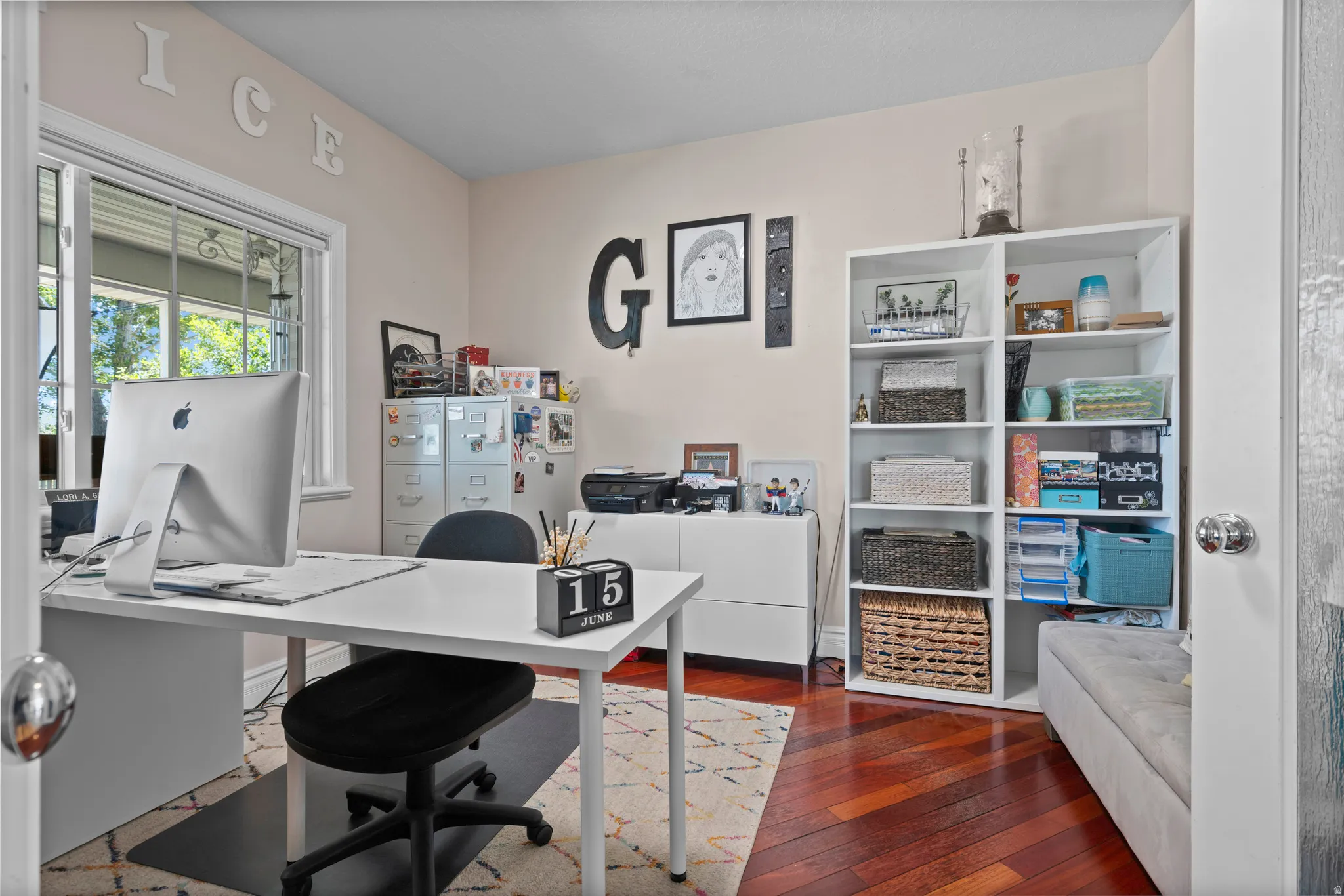 Dedicated room featuring wood-finish flooring, a white window frame, and neutral wall paint