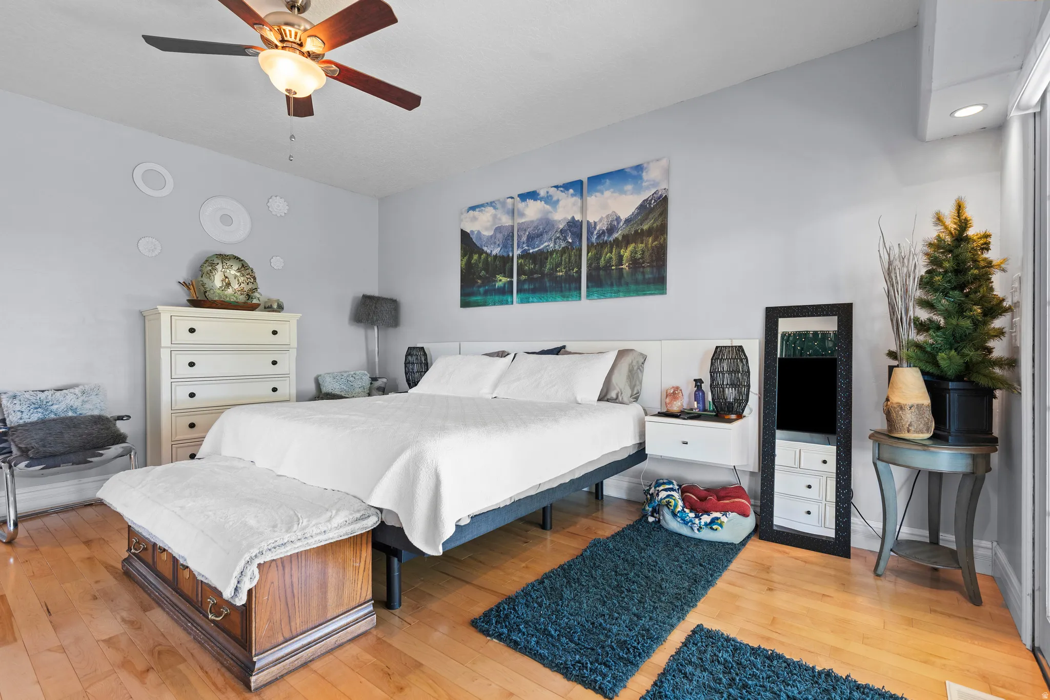 Expansive room featuring wood-finish flooring, a ceiling fan with integrated lighting, recessed lighting, and a large sliding glass door