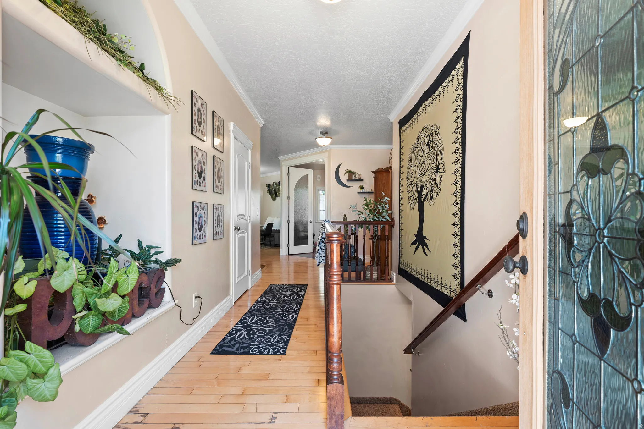 Entryway featuring wood-finish flooring, white baseboards, and crown molding