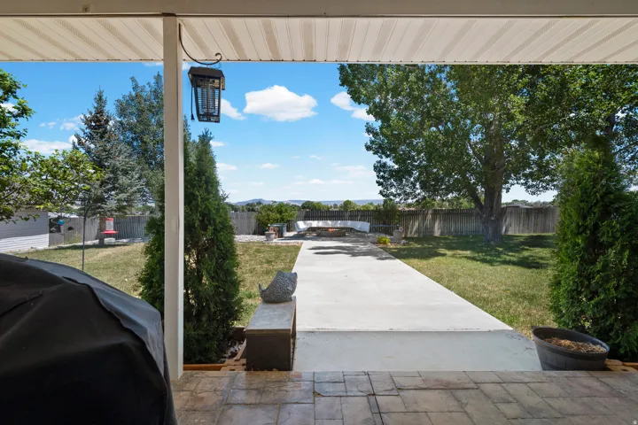 Covered patio with a patterned concrete surface opening to a spacious backyard