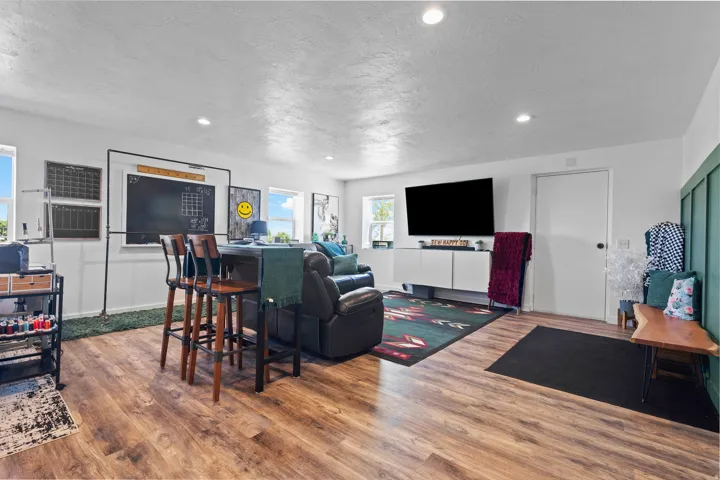 Spacious room featuring wood-finish flooring, recessed lighting, and multiple windows