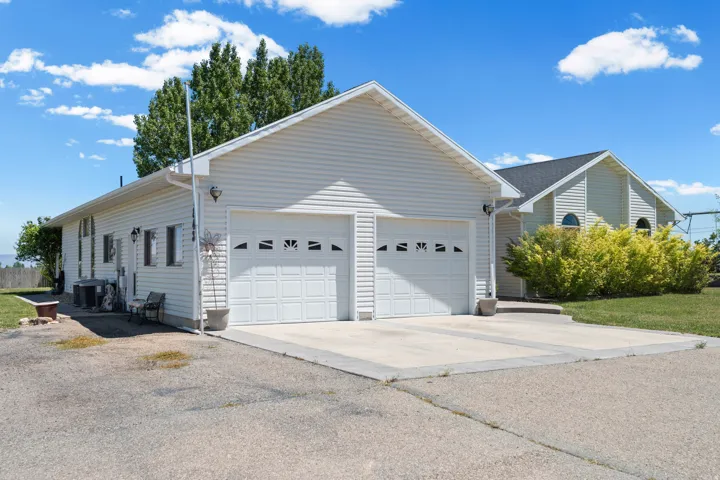 Attached two-car garage featuring panel doors with decorative windows and concrete driveway