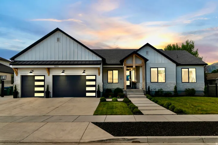 Modern farmhouse-style exterior featuring vertical board and batten siding, horizontal siding, and stone accents