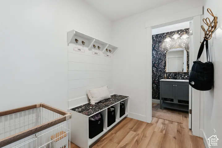 Mudroom area featuring a built-in bench with integrated storage cubbies and upper shelving with hooks