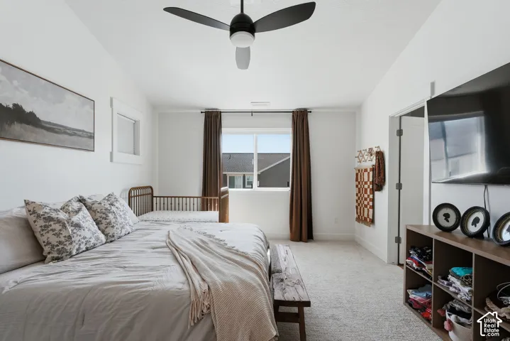 Bedroom featuring light-colored carpeting, white walls, and a modern ceiling fan