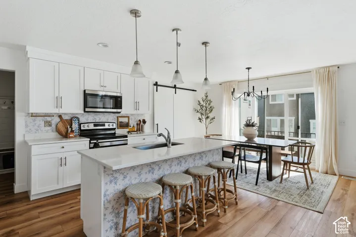 Open-concept kitchen and dining area featuring wood-finish flooring
