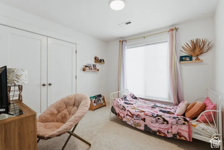 Bright room featuring light-colored carpeting and a window with blinds