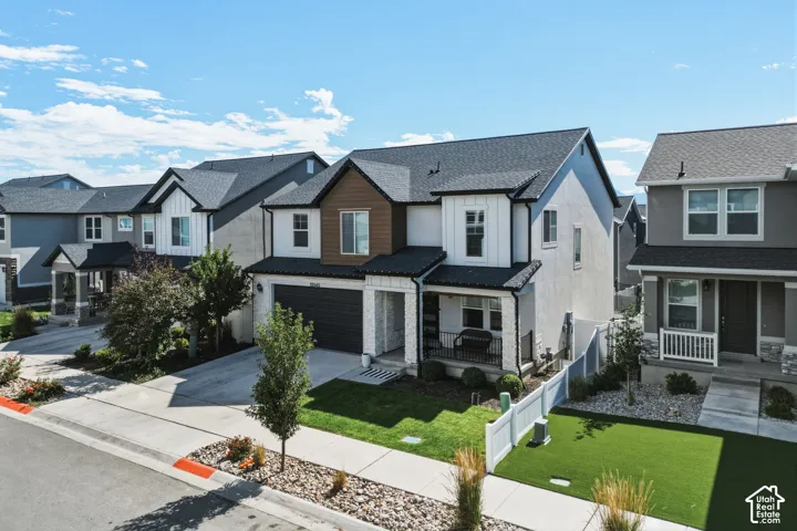 Modern multi-story residence featuring a dark asphalt shingle roof and a two-car garage
