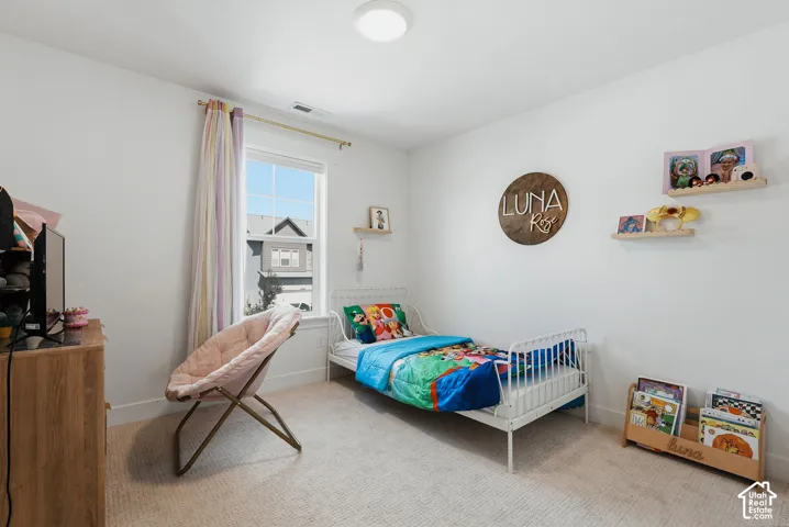 Bright room featuring light-colored carpeting and white walls