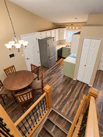 Vaulted ceilings define the dining area, featuring an ornate chandelier