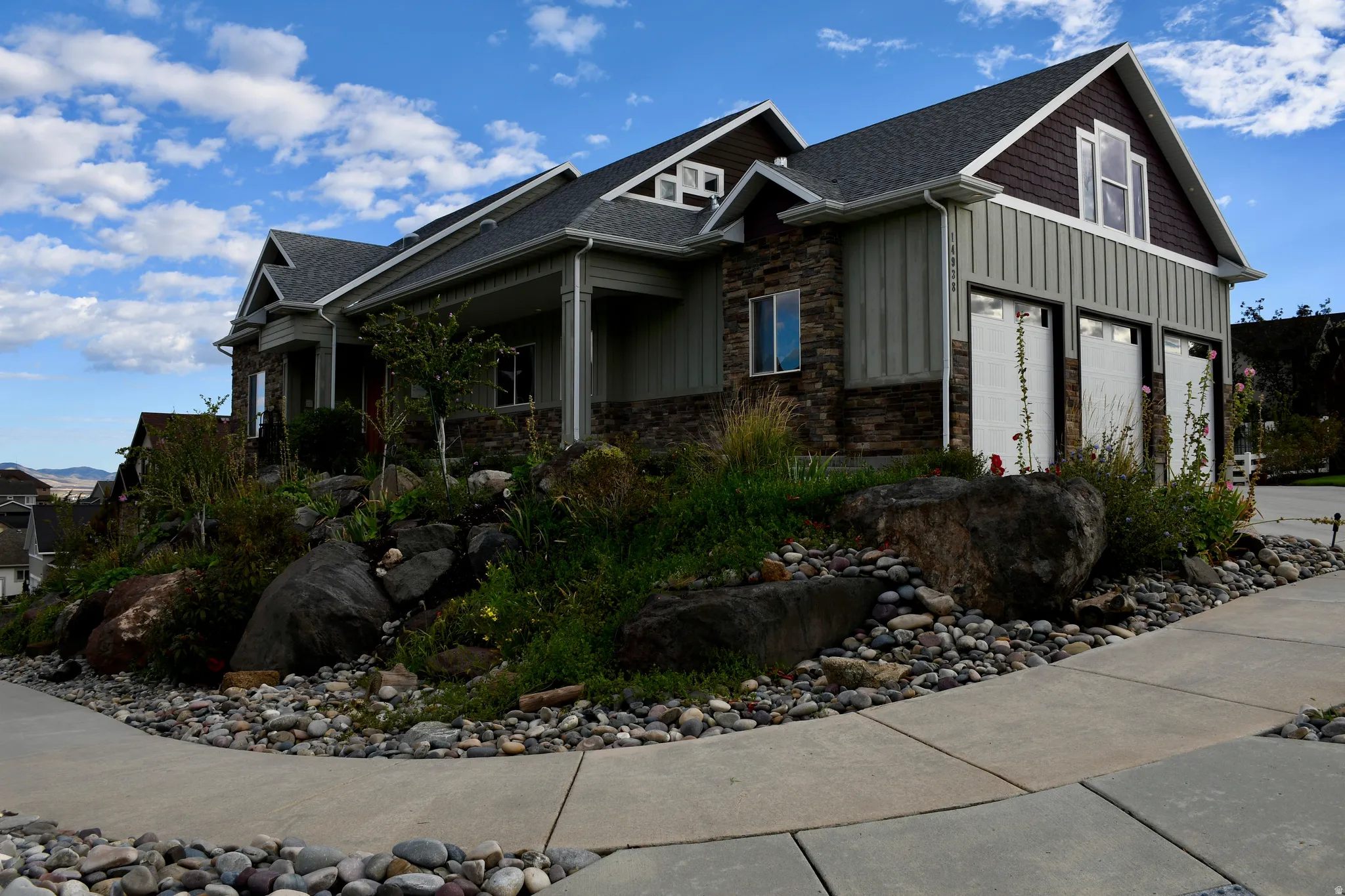 Stone and siding exterior with multiple gables and a covered entry