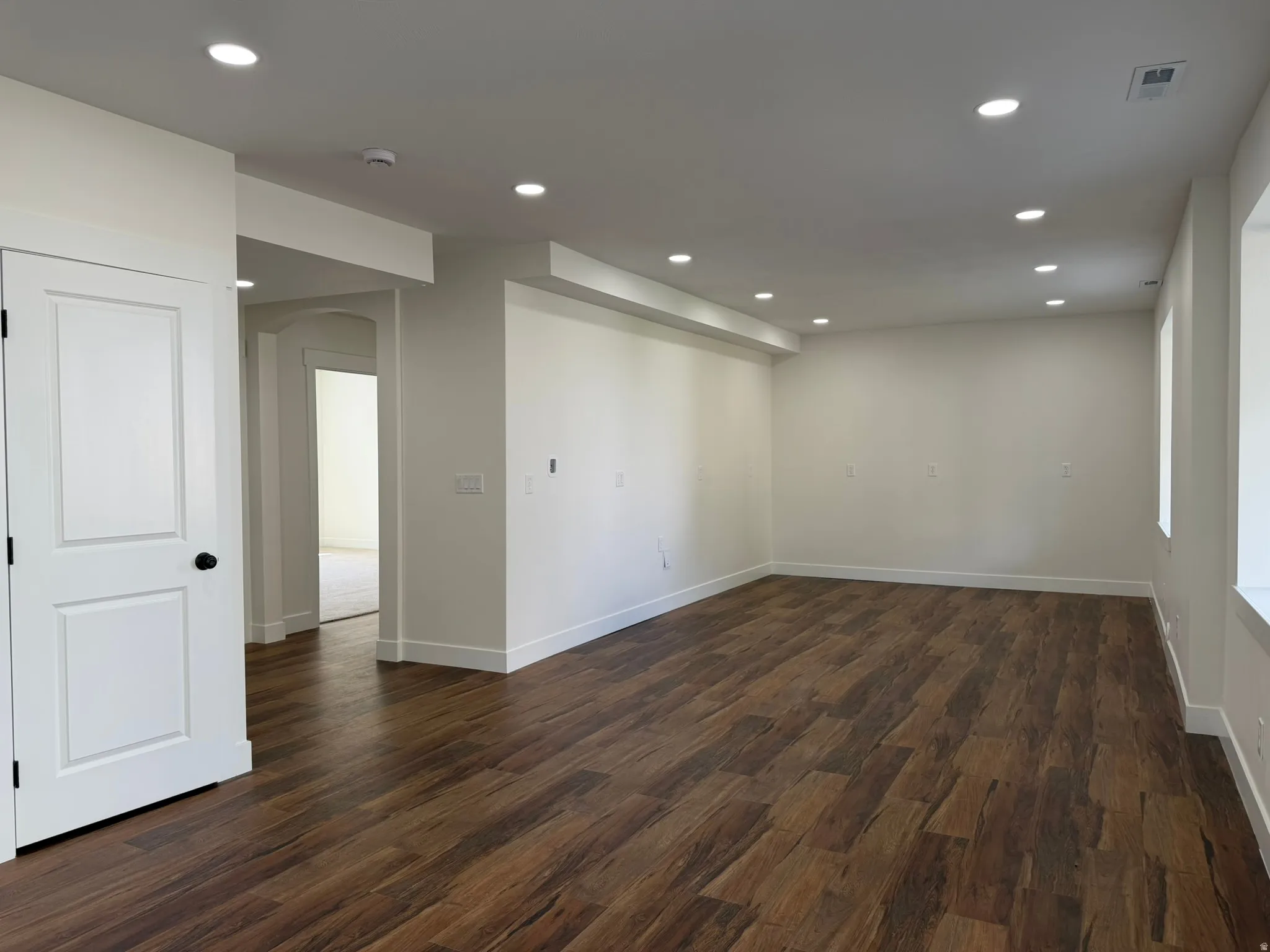 Wood-finish flooring throughout, recessed lighting, and bright white walls