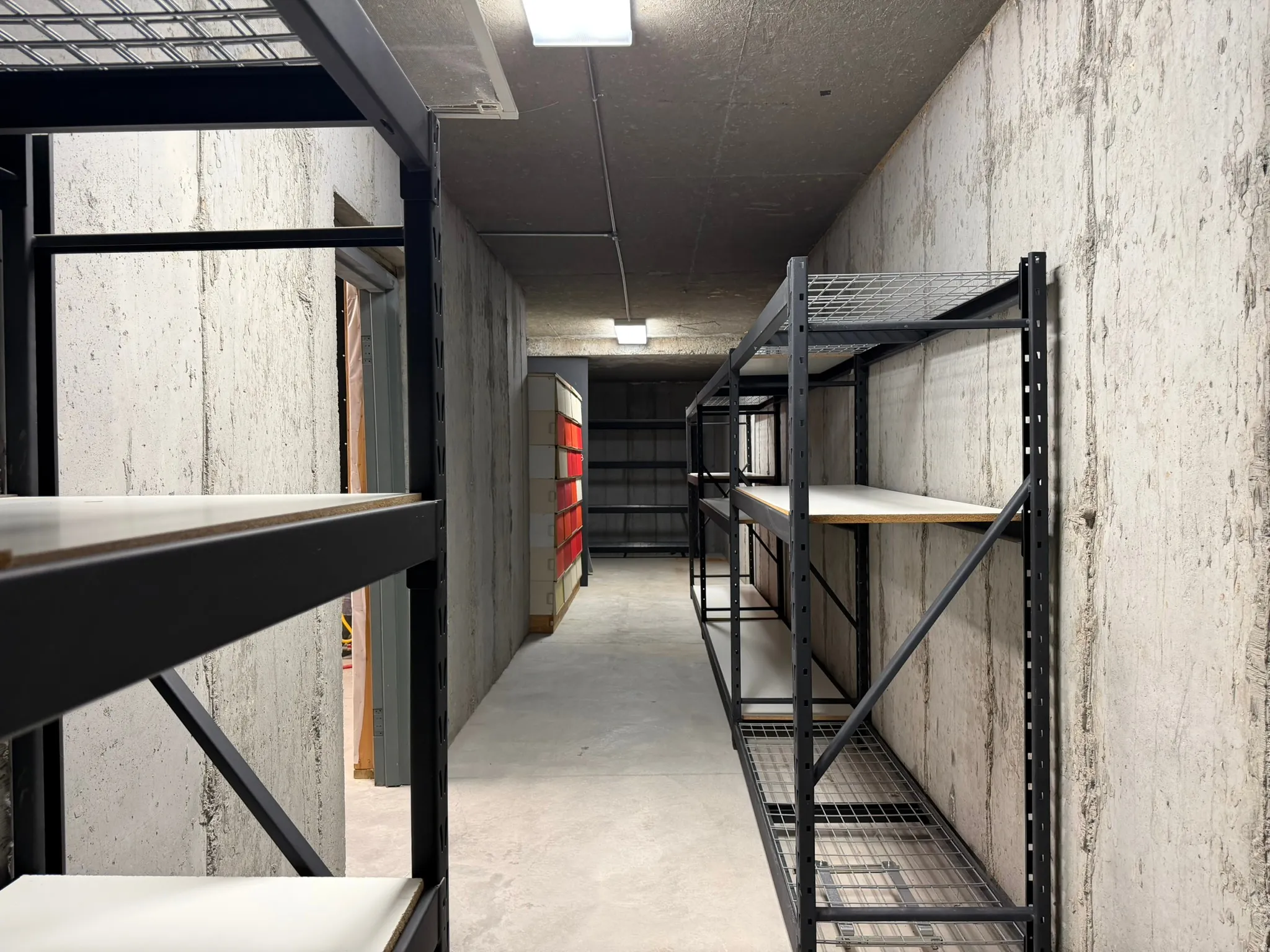 Concrete walls, concrete flooring, and overhead lighting