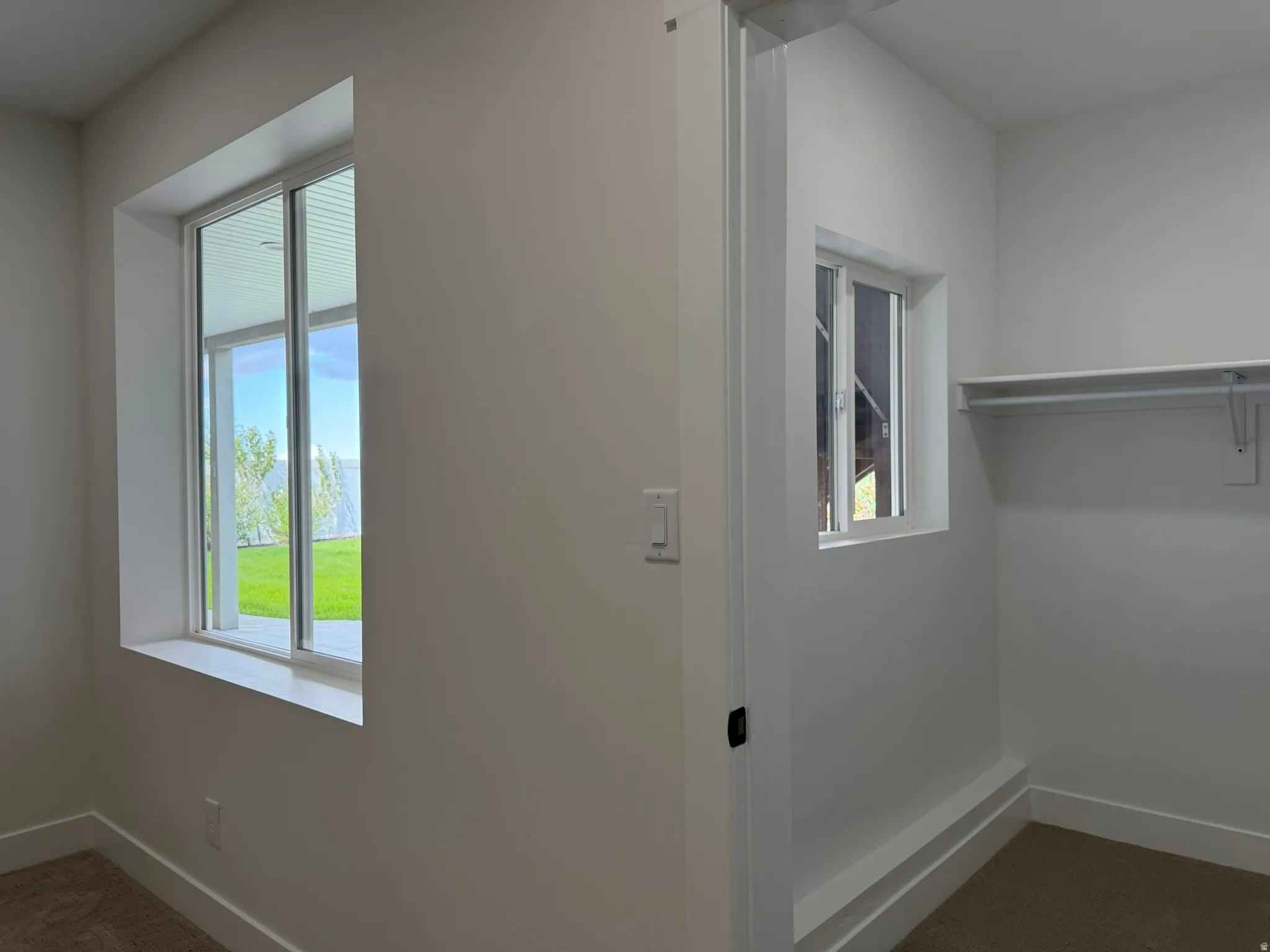 Crisp white walls, two window openings, and a built-in closet with shelving