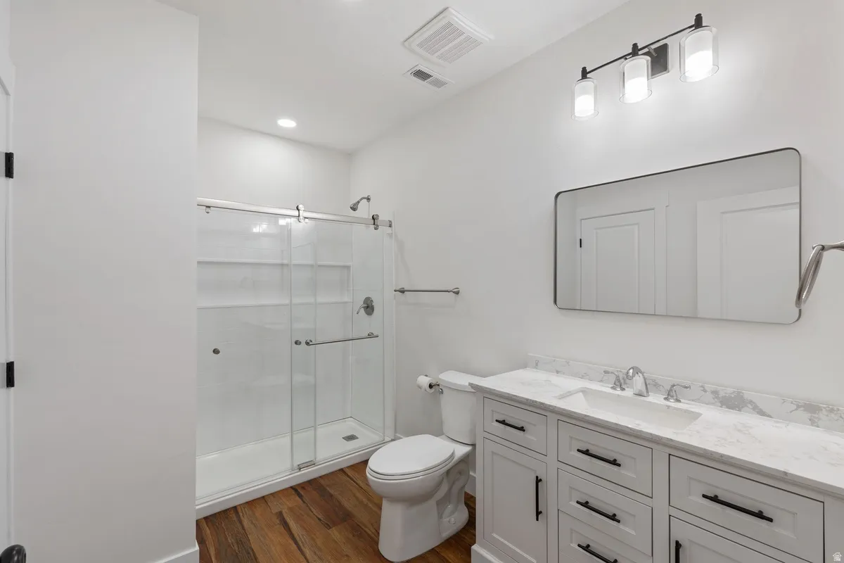 Bathroom featuring a white vanity with a stone-finish countertop, undermount sink, and black hardware
