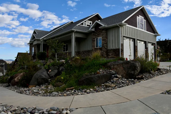 Stone and siding exterior with multiple gables and a covered entry