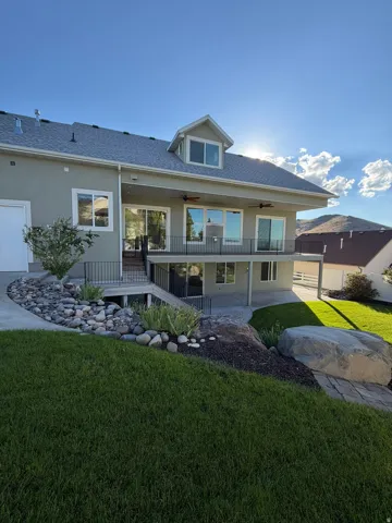 Stucco exterior with a dormer window and a covered upper-level deck