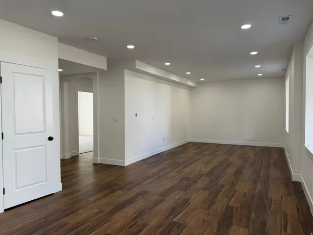 Wood-finish flooring throughout, recessed lighting, and bright white walls