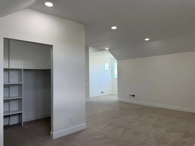 Recessed lighting, sloped ceilings, built-in closet shelving, and plush carpeting