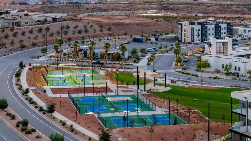 Community amenity area featuring multiple pickleball courts with shaded seating areas
