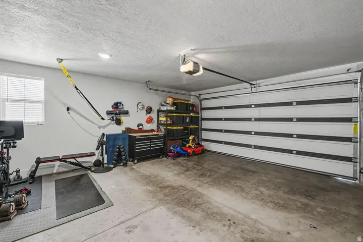 Single-car garage with a paneled overhead door and concrete flooring